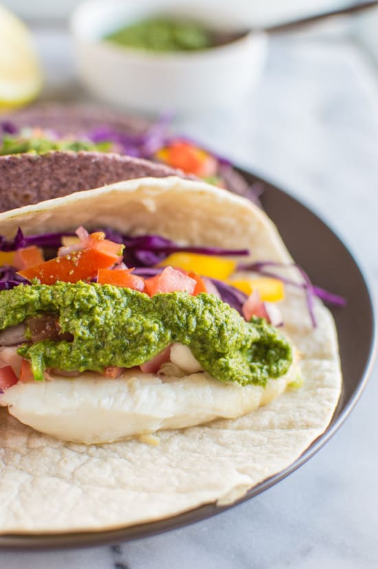 Delicious fish tacos with a spicy and tangy green harissa. Add some spice to your dinner or lunch with these healthy tacos! | clube.futebolmilionario.com