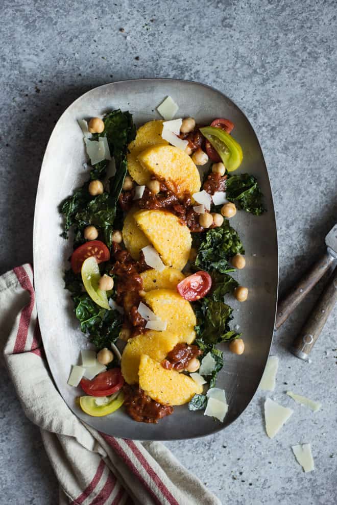 Pan Fried Polenta with Roasted Kale and Chickpeas - topped with tomatoes and parmesan cheese, this is the perfect light gluten-free dinner! Made with just 6 ingredients! by @healthynibs