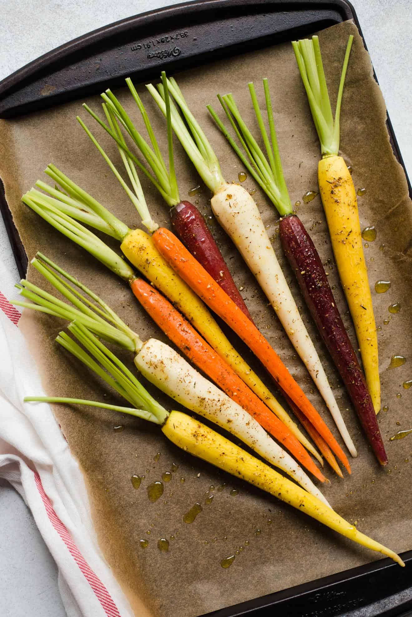 Preparing rainbow carrots for roasting with olive oil, salt, and za'atar