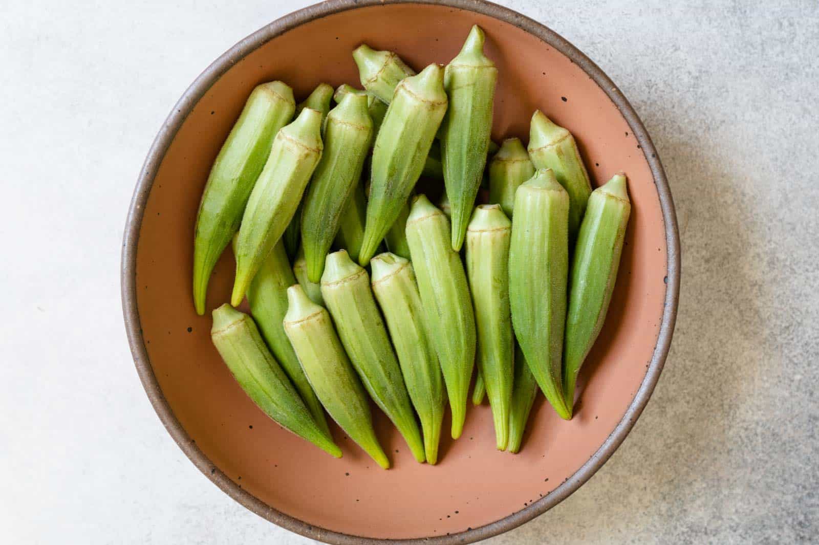 Okra in a bowl for July produce guide