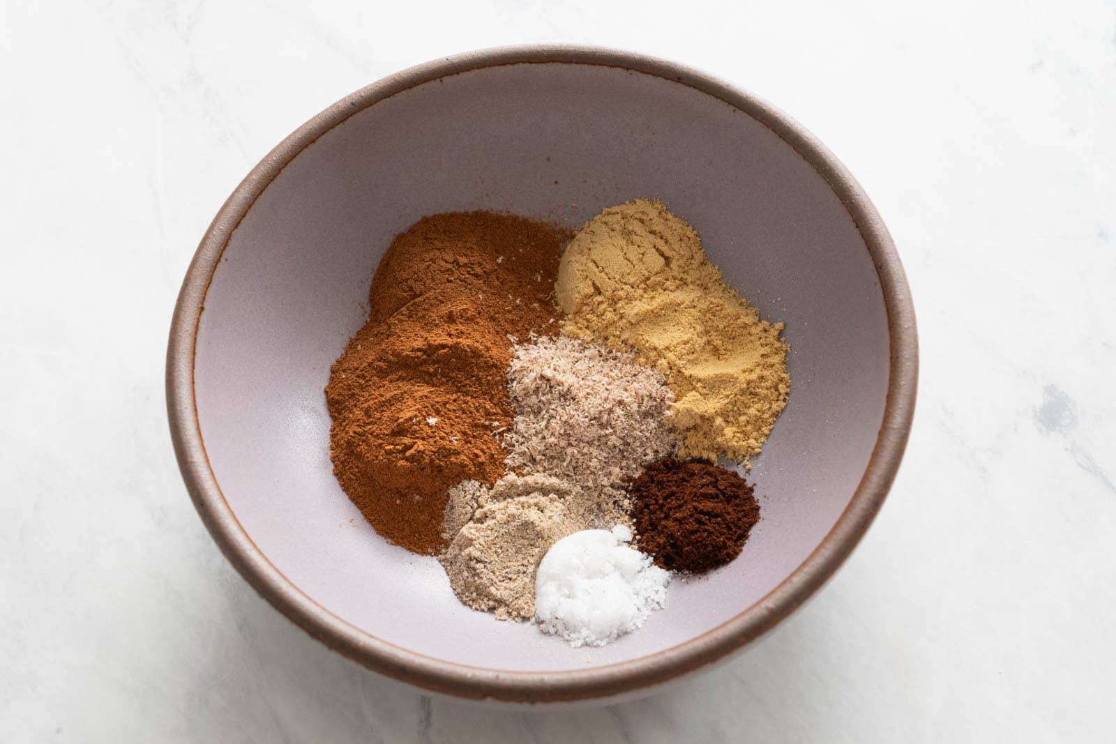 Cinnamon, ginger, nutmeg, cardamom, cloves, and salt in a bowl